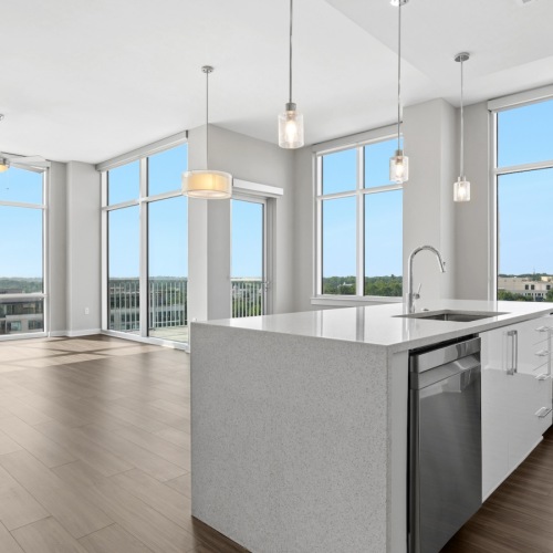 kitchen island in a large open room with walls of glass